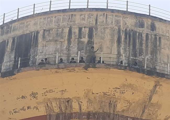 जनपद शाहजहांपुर में बिजली विभाग के संविदा मीटर रीडर पानी की टंकी पर चढ़े, बोले जब तक उनकी मांगेंं पूरी नहीं की जाती तब वेे नहीं उतरेंगे, जानिये मीटर रीडरों की क्या है मांग